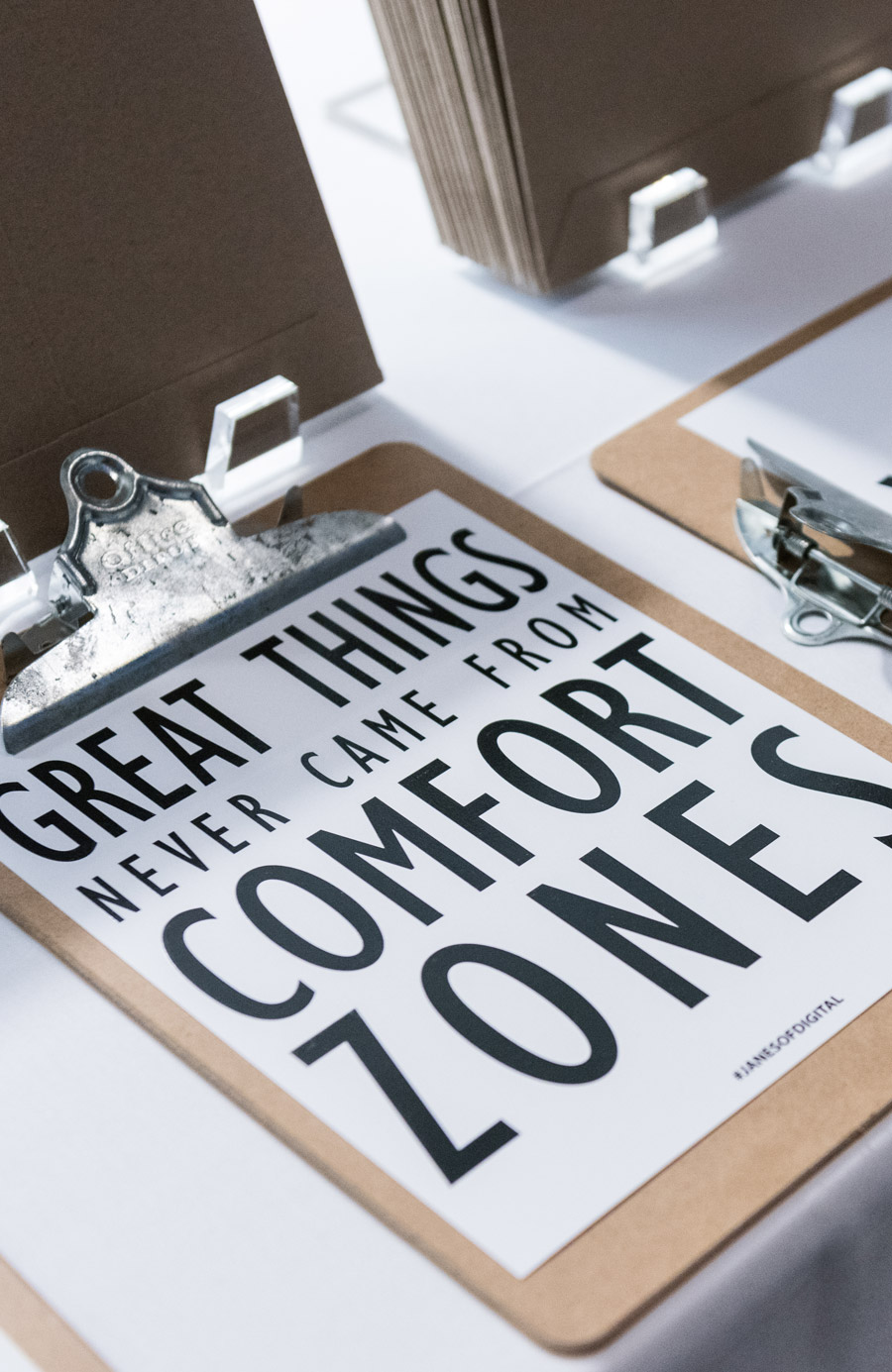 Clipboard with a piece of paper that says 'great things never came from comfort zones'.