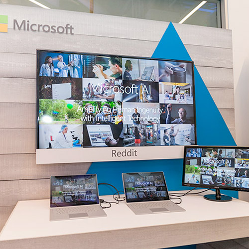 Microsoft branded booth with four computer screens.