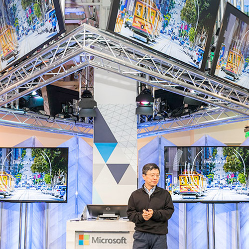 A presenter standing in front of a Microsoft branded booth.