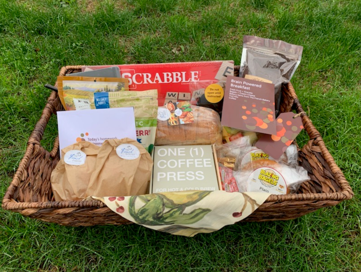 Giveaway package in a basket with coffee, treats, and games.